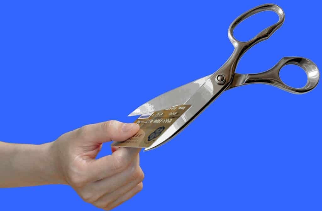 A hand with scissors cutting a credit card.