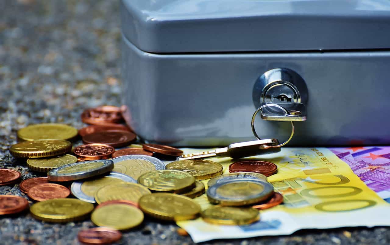 A photo of a lockbox with coins in front of it.